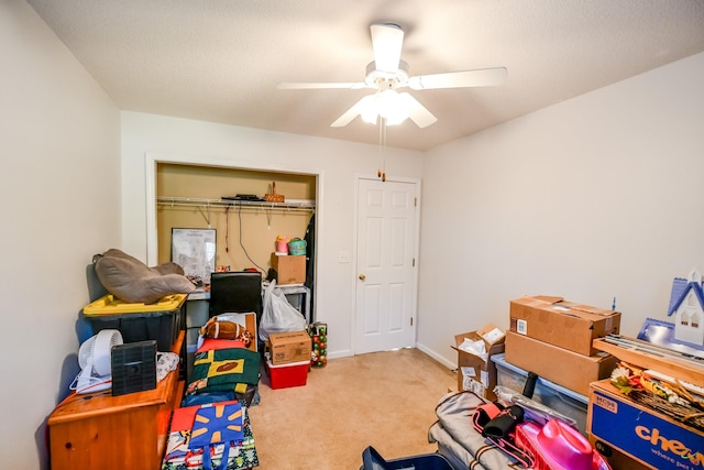 interior space with baseboards, a ceiling fan, and carpet flooring