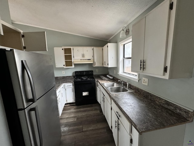 kitchen featuring under cabinet range hood, vaulted ceiling, freestanding refrigerator, black range with gas cooktop, and a sink