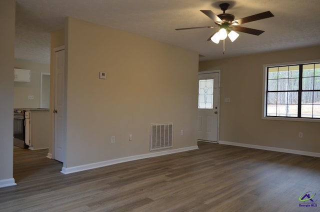 spare room featuring ceiling fan, wood finished floors, visible vents, and baseboards