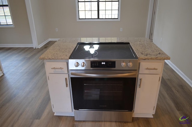 kitchen featuring white cabinets, electric stove, dark wood-style flooring, and a wealth of natural light