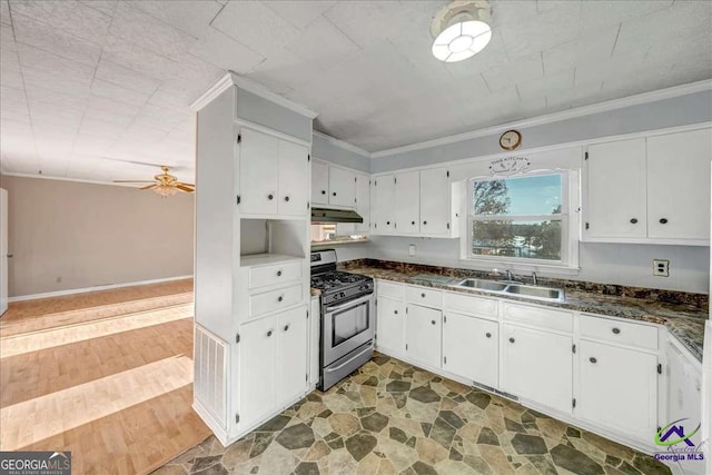 kitchen featuring gas stove, white cabinetry, ornamental molding, and a sink