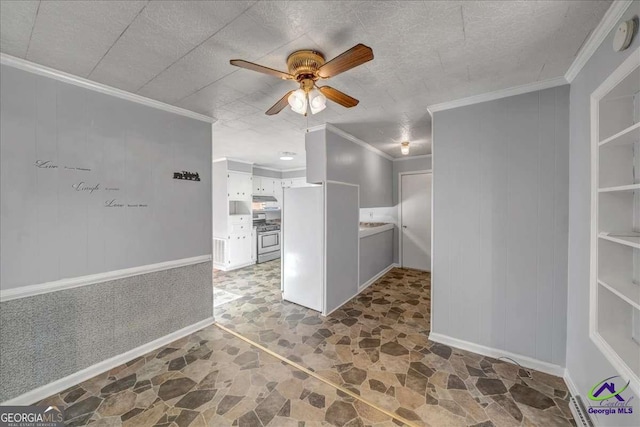 interior space with crown molding, stainless steel range with gas stovetop, stone finish floor, white cabinetry, and a ceiling fan