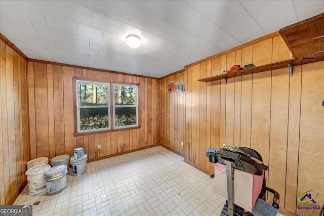 exercise area featuring baseboards and wood walls