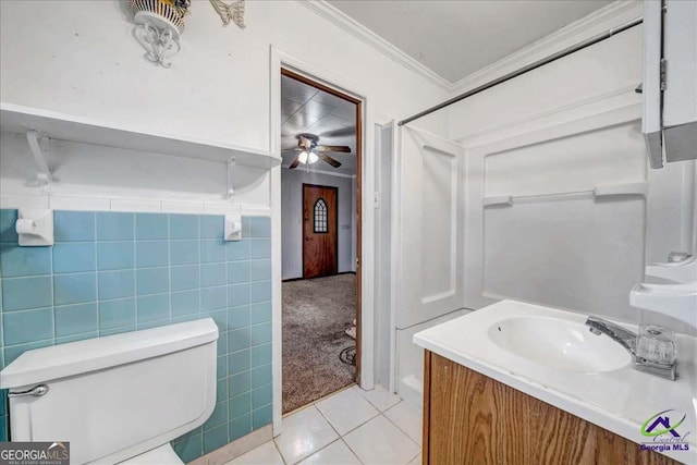 bathroom featuring tile patterned floors, toilet, tile walls, crown molding, and vanity