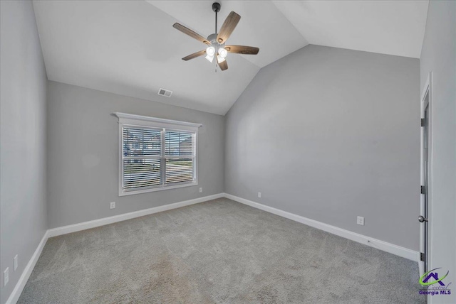 empty room with visible vents, lofted ceiling, carpet floors, baseboards, and ceiling fan