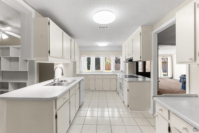 kitchen featuring visible vents, a sink, white appliances, light countertops, and light tile patterned floors