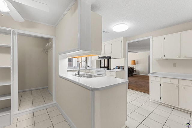 kitchen with ceiling fan, light countertops, light tile patterned floors, and a sink