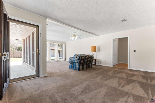 interior space with visible vents, baseboards, carpet floors, a textured ceiling, and a ceiling fan