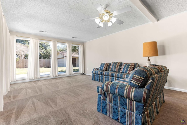 carpeted living room with a ceiling fan, baseboards, visible vents, and a textured ceiling