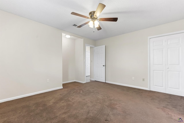 unfurnished bedroom with visible vents, baseboards, ceiling fan, a closet, and dark carpet