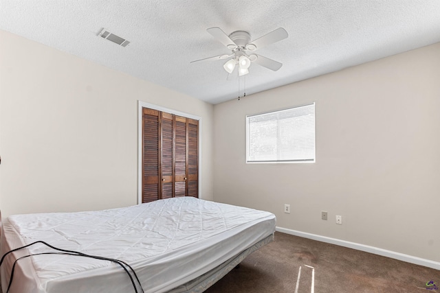 carpeted bedroom with a closet, visible vents, a textured ceiling, and baseboards