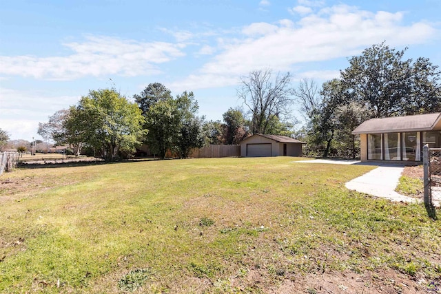 view of yard featuring an outbuilding, fence, and a detached garage