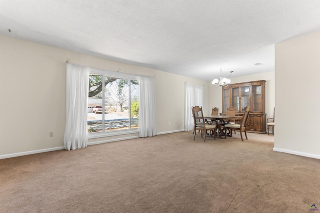 dining area featuring baseboards, carpet floors, a textured ceiling, and a chandelier