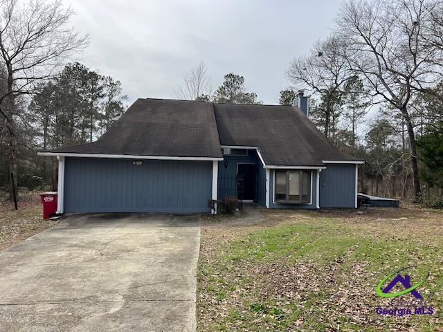 ranch-style house with a garage, driveway, and a chimney