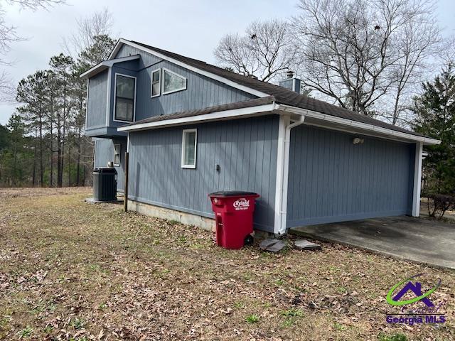 view of side of home with central AC and a chimney