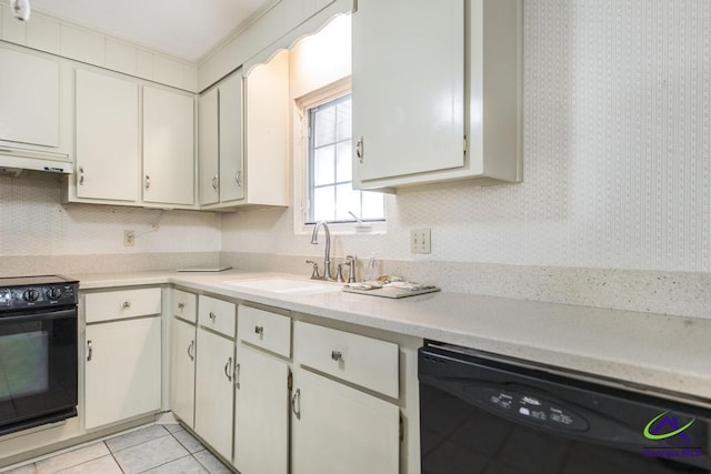 kitchen with light tile patterned floors, a sink, black appliances, light countertops, and under cabinet range hood