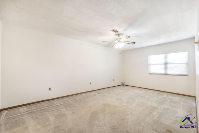 unfurnished room featuring a textured ceiling, a ceiling fan, baseboards, visible vents, and light carpet