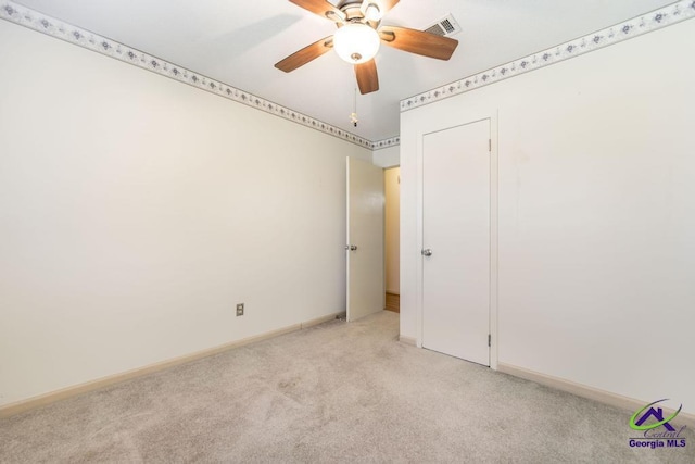 empty room with visible vents, baseboards, light colored carpet, and a ceiling fan