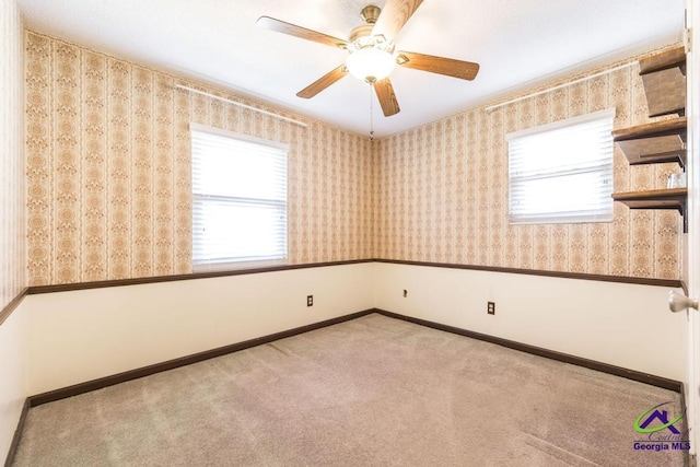 empty room with plenty of natural light, wallpapered walls, baseboards, and carpet floors