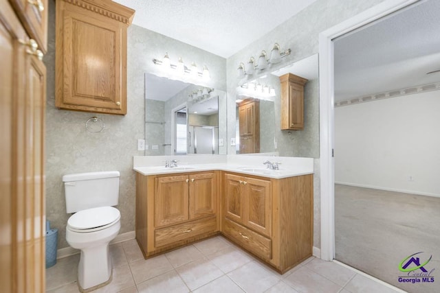 bathroom featuring a sink, toilet, double vanity, and tile patterned floors