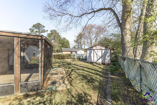 view of yard featuring a storage unit, an outdoor structure, and fence