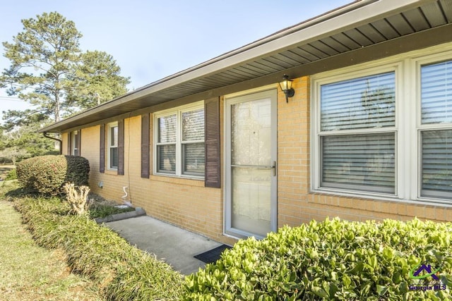 entrance to property featuring brick siding