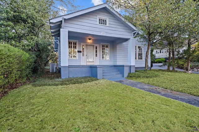 bungalow with a front lawn, a porch, and central AC