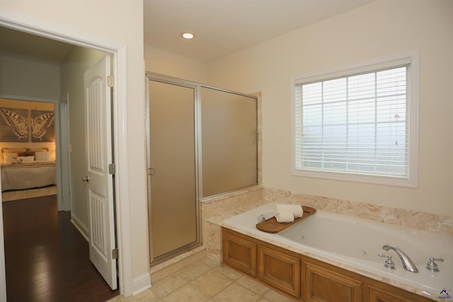 ensuite bathroom featuring recessed lighting, connected bathroom, a stall shower, and a whirlpool tub