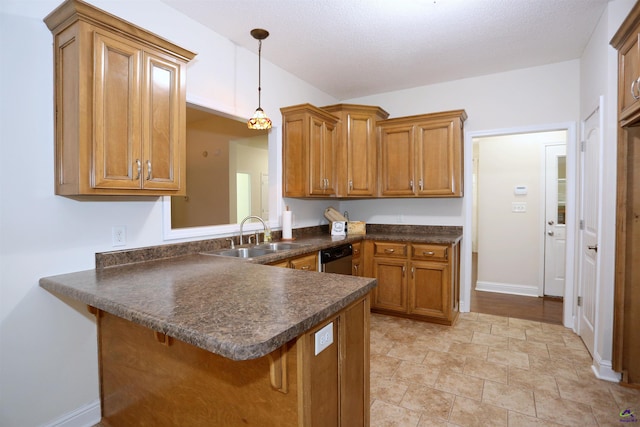 kitchen with dark countertops, a peninsula, brown cabinets, and a sink