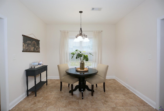 dining area featuring baseboards, visible vents, and a chandelier