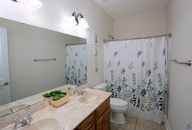 bathroom featuring tile patterned flooring, double vanity, toilet, and a sink