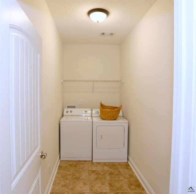 laundry area featuring laundry area, washing machine and dryer, baseboards, and visible vents