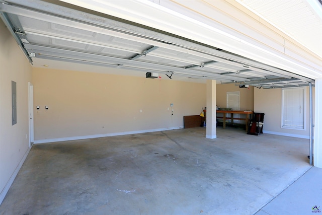 garage with electric panel, a garage door opener, and baseboards