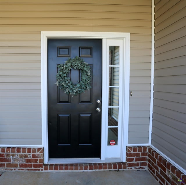 doorway to property featuring brick siding