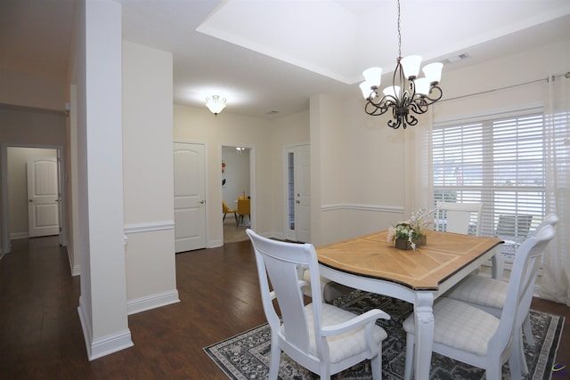 dining area with an inviting chandelier, visible vents, wood finished floors, and baseboards