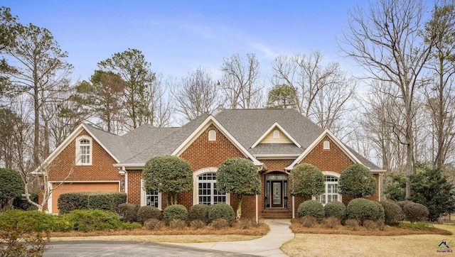 traditional-style house featuring brick siding and a shingled roof