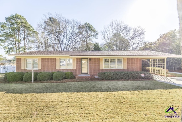 ranch-style home with brick siding, concrete driveway, and a front lawn