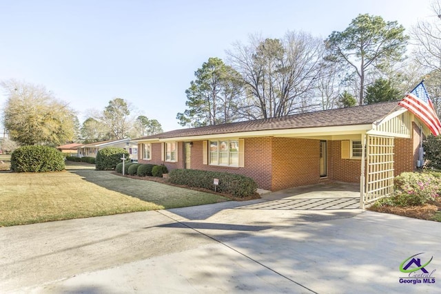 ranch-style home featuring brick siding, an attached carport, concrete driveway, and a front lawn