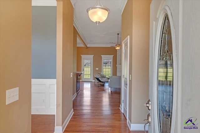 entryway with baseboards, a ceiling fan, wood finished floors, and crown molding