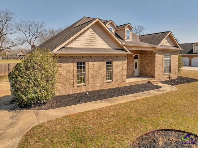 view of front of property with a patio area, brick siding, a front yard, and fence