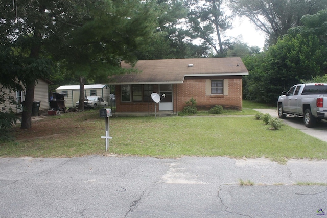 view of front facade featuring brick siding and a front lawn