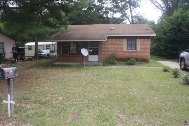 view of front of property featuring brick siding and a front yard