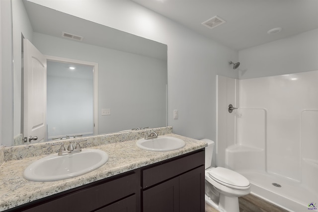 bathroom featuring a sink, visible vents, a shower, and toilet