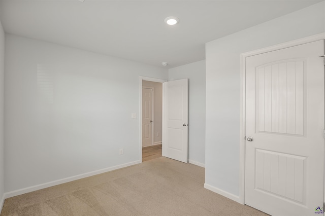 unfurnished bedroom with light carpet and baseboards