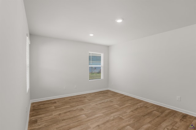 empty room featuring recessed lighting, baseboards, and light wood-style flooring