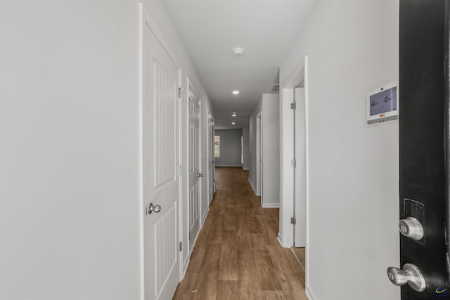 corridor with recessed lighting, baseboards, and wood finished floors