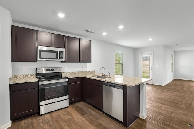 kitchen featuring dark wood-style floors, visible vents, a sink, stainless steel appliances, and dark brown cabinets