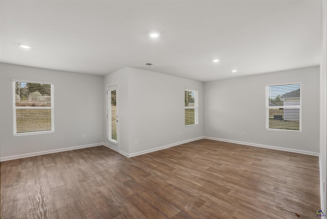 unfurnished room with visible vents, recessed lighting, wood finished floors, and baseboards