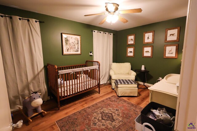 bedroom featuring wood finished floors, baseboards, and ceiling fan