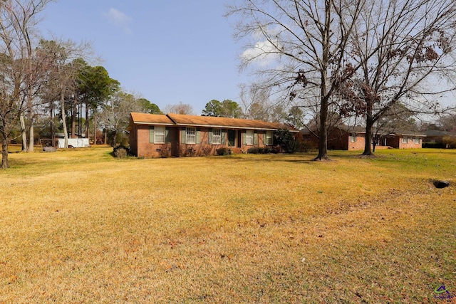 view of front of house with brick siding and a front lawn